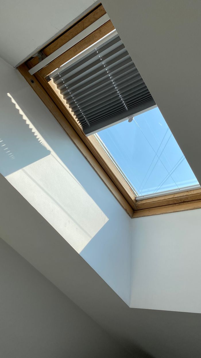 services-02 A ceiling skylight with blinds allows natural light into a minimalist interior. Perfect for architectural and design needs.