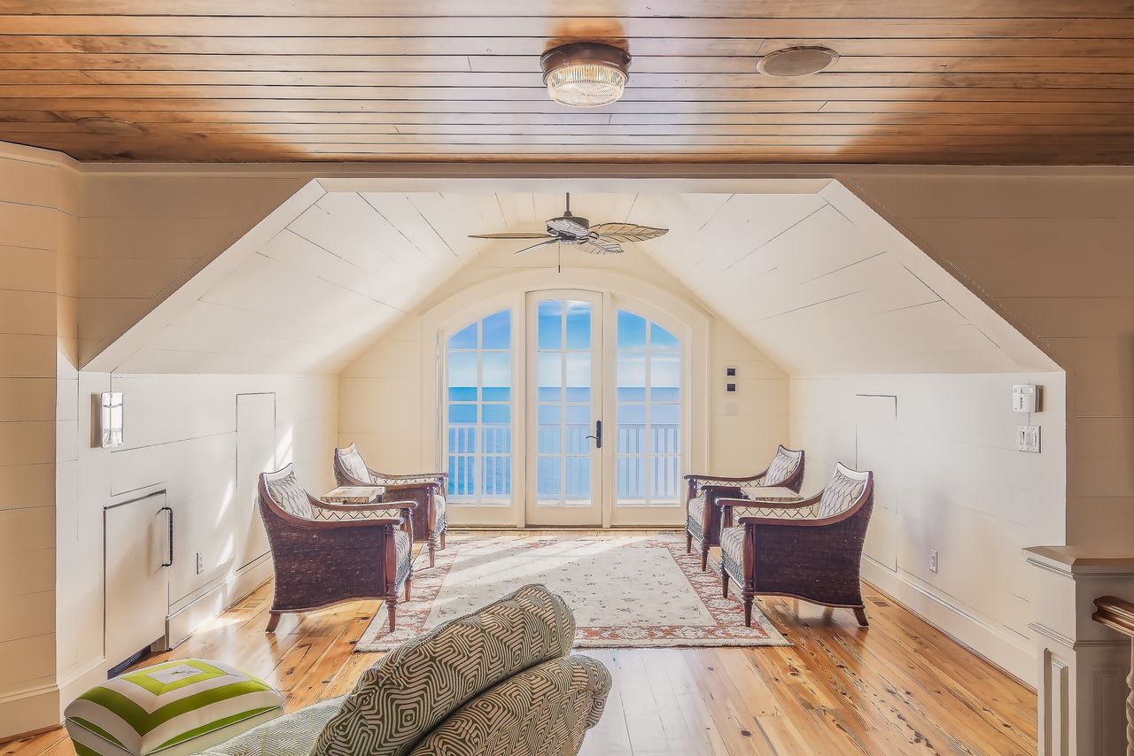 who-we-are Bright and luxurious loft overlooking the ocean, featuring modern furniture and design.