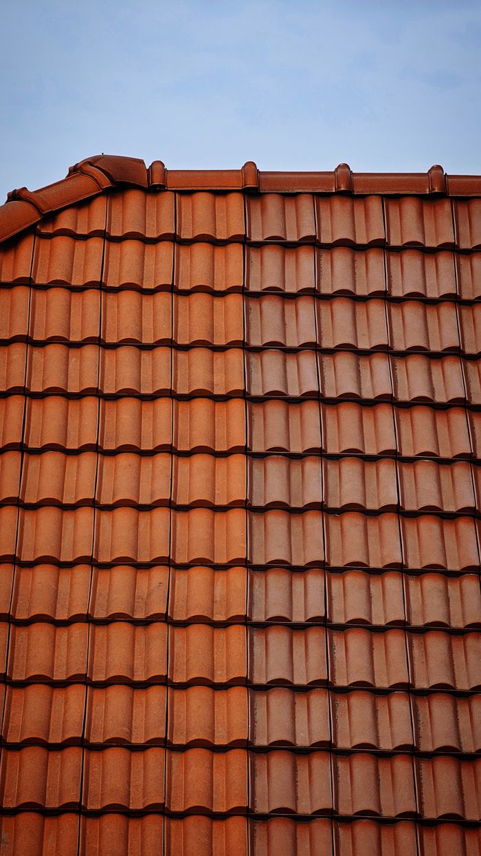 The Art of Drawing Readers In: Your attractive post title goes here Detailed view of classic red clay roof tiles under a clear blue sky.