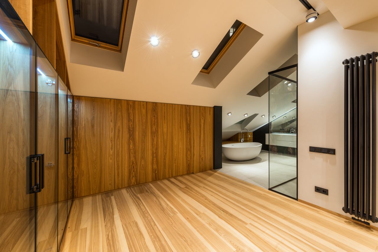 our-story Creative design of bathroom with bath on floor under windows illuminated by lamps in house